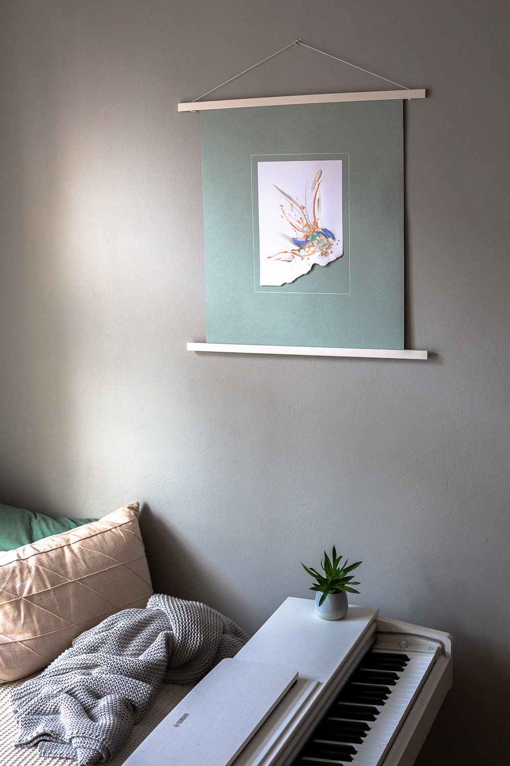perseverance i is an original abstract artwork by Rose Reichart. Here it is featured in a home with modern interior design in neutral shades. The intuitive painting is mounted on a mint colored paper and hangs on the wall with a white magnetic poster frame. Muted colors in tones of mint, peach, sage, beige and gray are present in the piece.