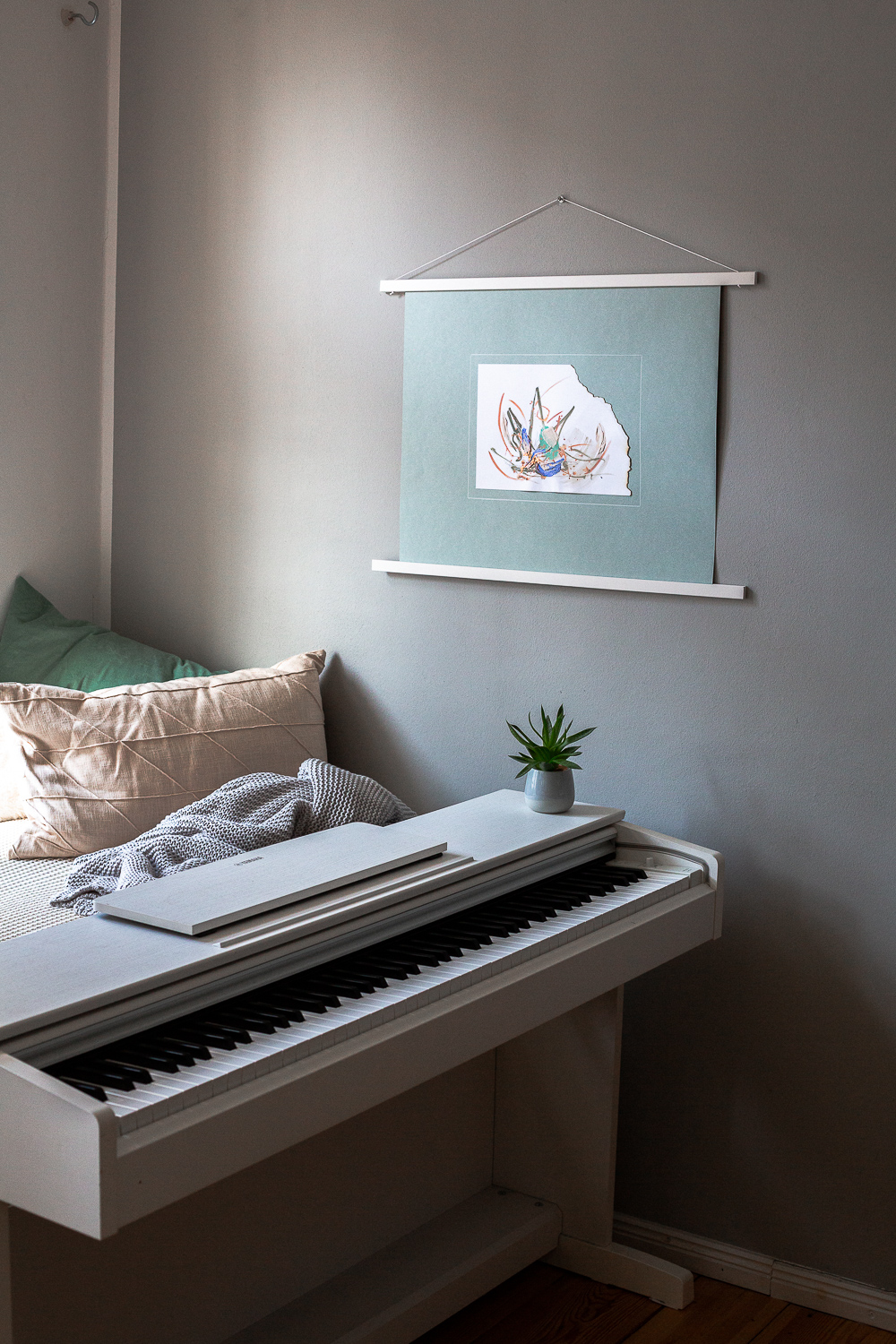 perseverance ii is an original abstract artwork by Rose Reichart. Here it is featured in a home with modern interior design in neutral shades. The intuitive painting is mounted on a mint colored paper and hangs on the wall with a white magnetic poster frame. Muted colors in tones of mint, peach, sage, beige and gray are present in the piece.